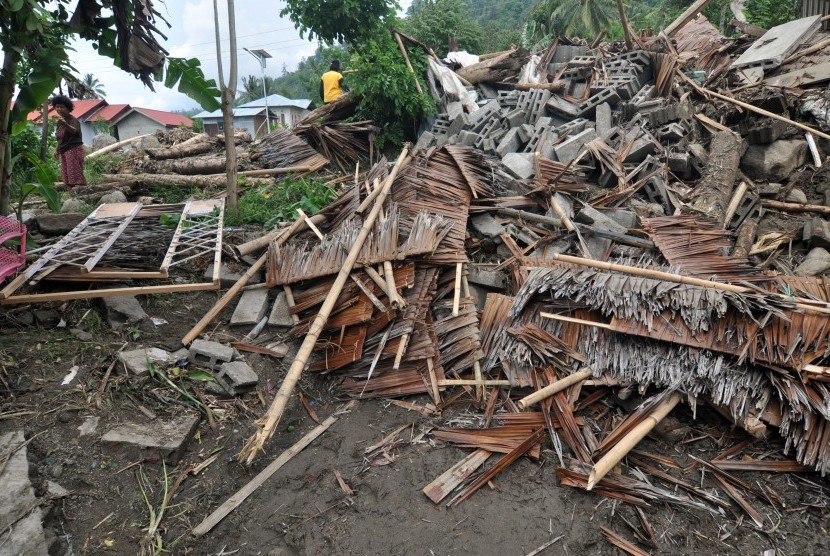 Warga berada disekitar rumah yang hancur akibat diterjang banjir bandang di Dusun Pangana, Desa Bolapapu, Kecamatan Kulawi, Kabupaten Sigi, Sulawesi Tengah, Jumat (13/12/2019). 