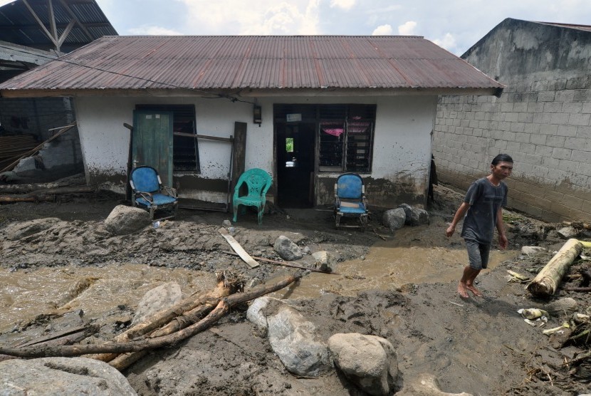 Warga berada disekitar rumah yang rusak akibat diterjang banjir bandang di Dusun Pangana, Desa Bolapapu, Kecamatan Kulawi, Kabupaten Sigi, Sulawesi Tengah, Jumat (13/12/2019).