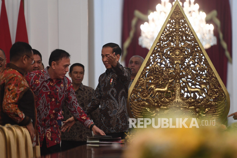 Presiden Joko Widodo (kanan) mempersilakan Ketua Umum PSSI Mochammad Iriawan (kedua kiri) dan rombongan sebelum pertemuan di Istana Merdeka, Jakarta, Senin (16/12).