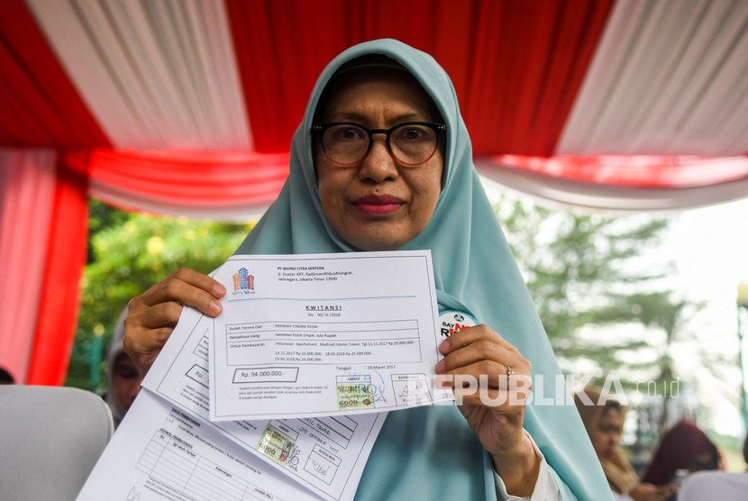 Korban kasus sindikat mafia perumahan syariah menunjukan bukti transaksi pembelian rumah saat hadir dalam rilis kasus di Polda Metro Jaya, Jakarta, Senin (16/12/2019).