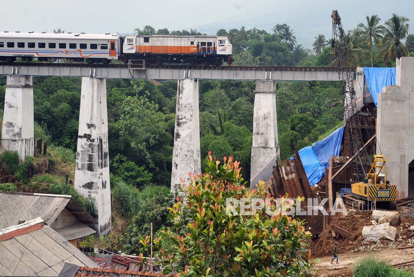 Kereta Pangrango relasi Sukabumi-Bogor melintas di samping proyek pembangunan jalur rel ganda Bogor-Sukabumi di Cigombong, Kabupaten Bogor, Jawa Barat, Senin (16/12/2019). 