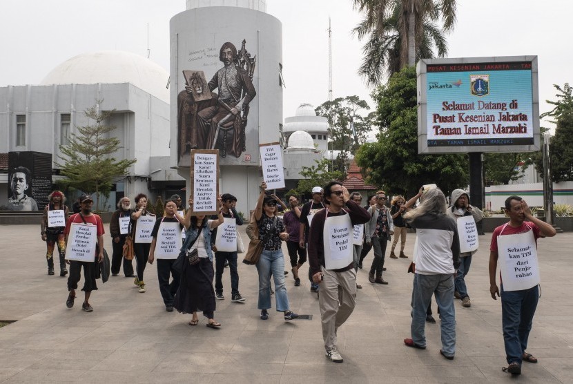Seniman yang tergabung dalam Forum Seniman Peduli Taman Ismail Marzuki (TIM) membentangkan poster pada aksi mimbar bebas di kawasan TIM, Cikini, Jakarta, Senin (16/12/2019).