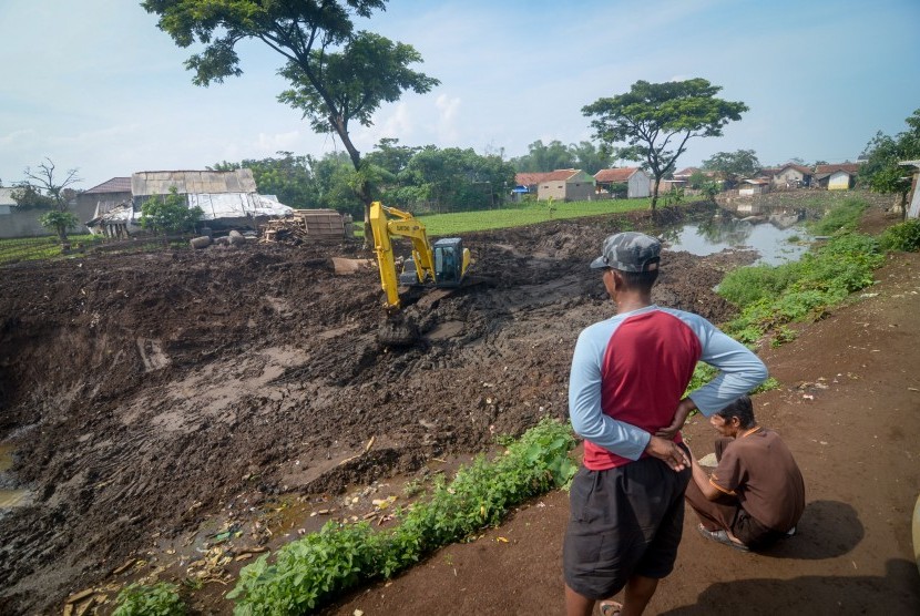 Satu Juta Pohon Ditanam Sepanjang DAS Citarum. Warga menyaksikan pekerja yang mengoperasikan alat berat pada proyek normalisasi Sungai Citarum di Oxbow Sapan, Kabupaten Bandung, Jawa Barat.