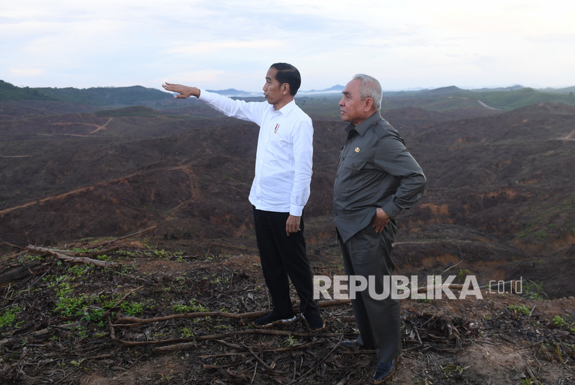 Presiden Joko Widodo (kiri) berbincang dengan Gubernur Kalimantan Timur Isran Noor (kanan) saat meninjau lokasi rencana ibu kota baru di Sepaku, Penajam Paser Utara, Kalimantan Timur, Selasa (17/12/2019).