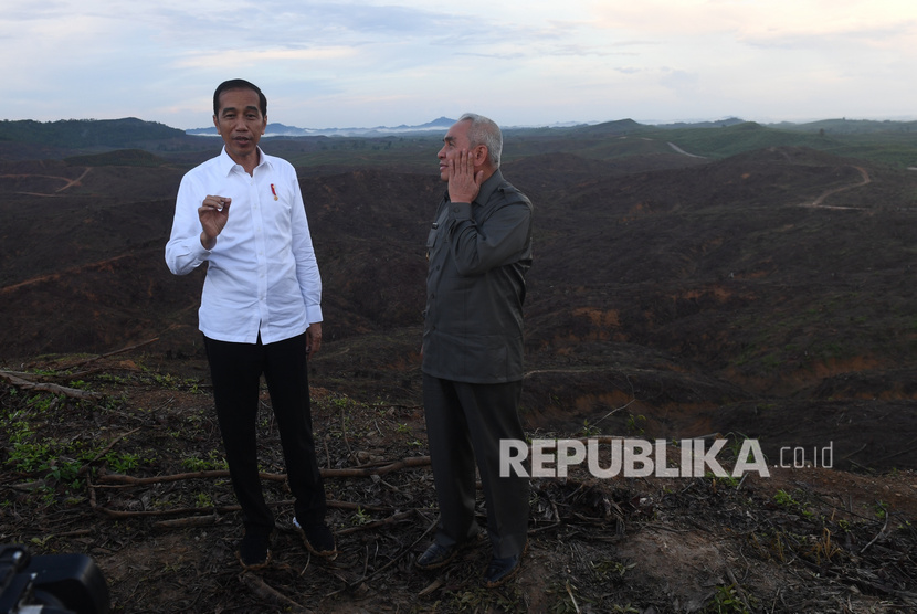 Presiden Joko Widodo (kiri) berbincang dengan Gubernur Kalimantan Timur Isran Noor (kanan) saat meninjau lokasi rencana ibu kota baru di Sepaku, Penajam Paser Utara, Kalimantan Timur, Selasa (17/12/2019). 