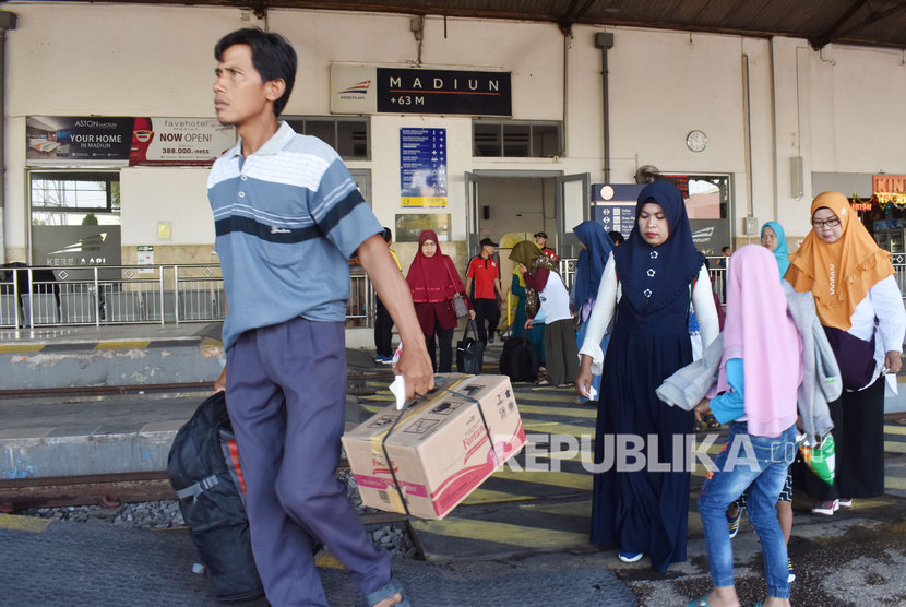 Sejumlah penumpang turun dari Kereta Api (KA) di Stasiun KA Madiun, Jawa Timur.