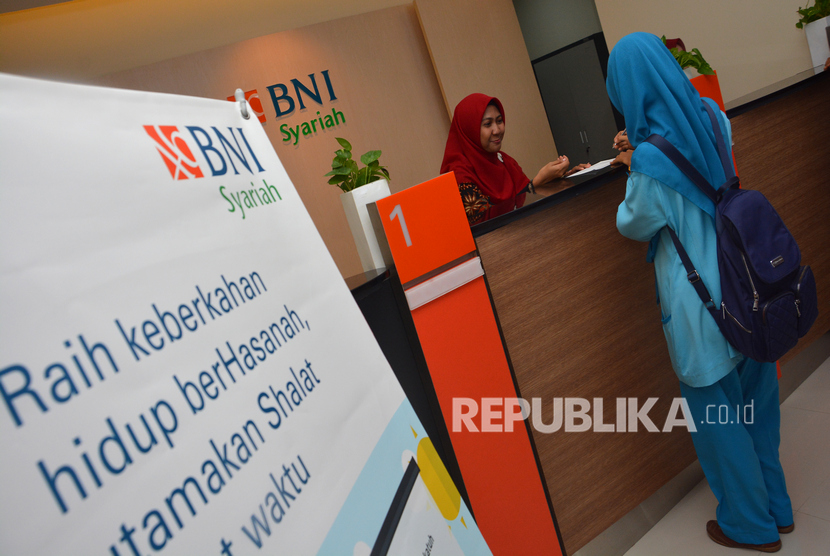 Petugas teller bank melayanai nasabah usai peresmian kantor cabang pembantu (KCP) BNI Syariah Jombang, Jawa Timur, Senin (23/12/2019). (Antara/Syaiful Arif)