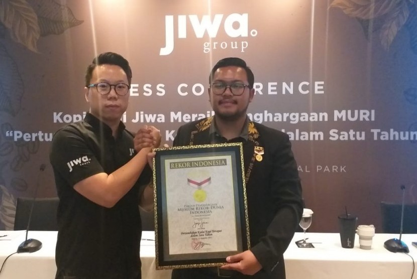 CEO dan Founder Kopi Janji Jiwa Billy Kurniawan (kiri) menerima muri untuk Kopi Janji Jiwa atas rekor Pertumbuhan Kedai Kopi Tercepat Dalam Satu Tahun, di Central Park Jakarta, Senin (23/12).