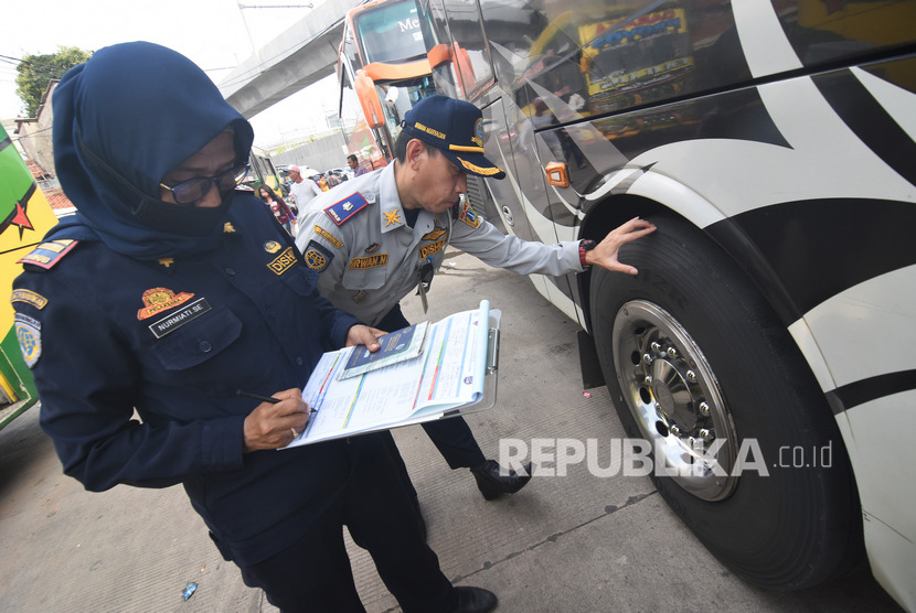 Petugas Dinas Perhubungan DKI Jakarta memeriksa kondisi ban saat pemeriksaan kelaikan angkutan Antar Kota Antar Provinsi (AKAP) di Terminal Lebak Bulus, Jakarta Selatan
