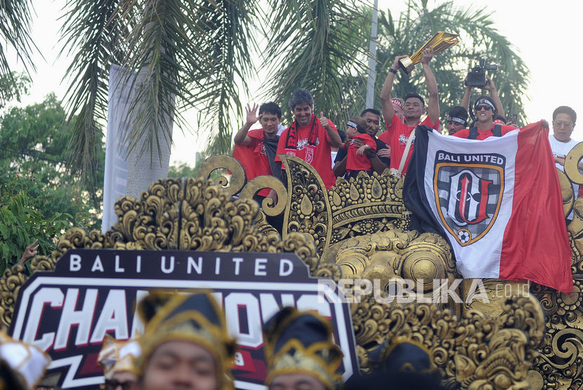 Para pemain dan ofisial tim Bali United menyapa pendukungnya dari atas mobil hias saat mengikuti Parade Juara Liga 1 2019 di kawasan Gianyar, Bali, Senin (23/12/2019).