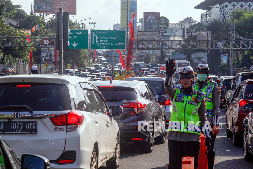 Polisi mengatur arus kendaraan di jalur Puncak, Bogor, Jawa Barat, Senin (30/12/2019).