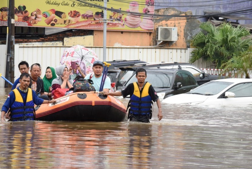 Petugas SAR menggunakan perahu karet mengevakuasi korban banjir di Perumahan Jati Bening Permai, Bekasi, Rabu (01/01/2020).