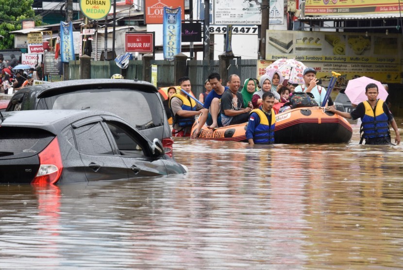 Petugas SAR menggunakan perahu karet mengevakuasi korban banjir di Perumahan Jati Bening Permai, Bekasi, Rabu (01/01/2020).