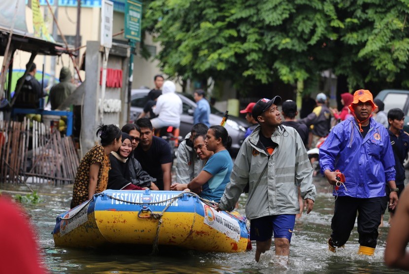 Tim penyelamat mengevakuasi korban banjir. Warga Tangsel meninggal diduga tersengat listrik ketika bersihkan stop kontak usai banjir