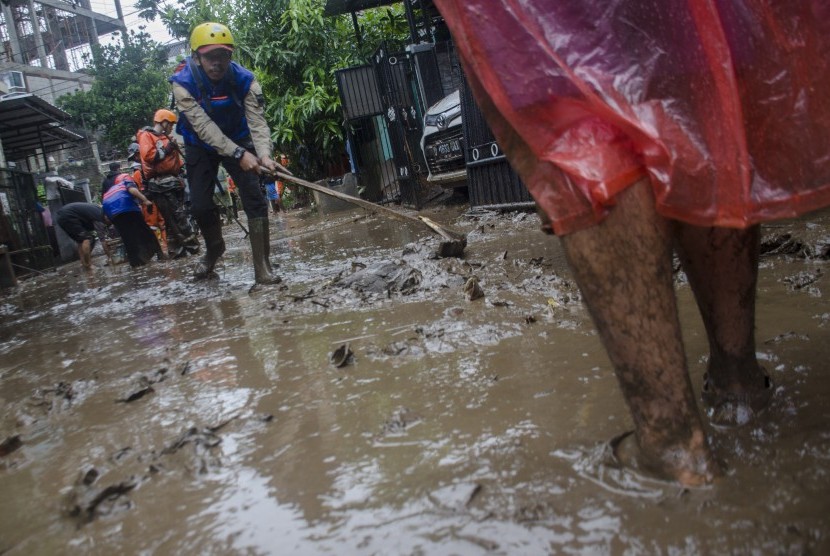 Petugas bersama warga membersihkan sisa lumpur pascabanjir bandang di Cimareme, Kabupaten Bandung Barat, Jawa Barat, Kamis (1/1/2020).