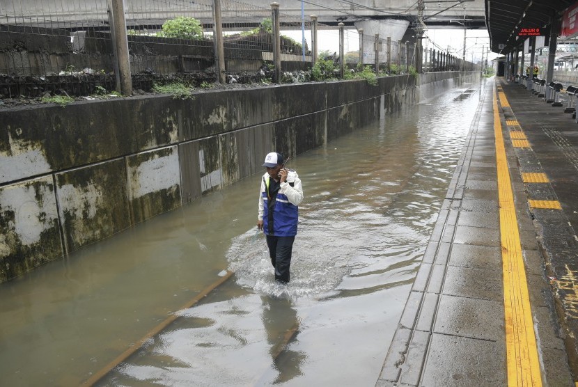 Petugas memeriksa rel kereta api yang terendam banjir di Stasiun KA Tanah Abang, Jakarta, Rabu (1/1/2020). 