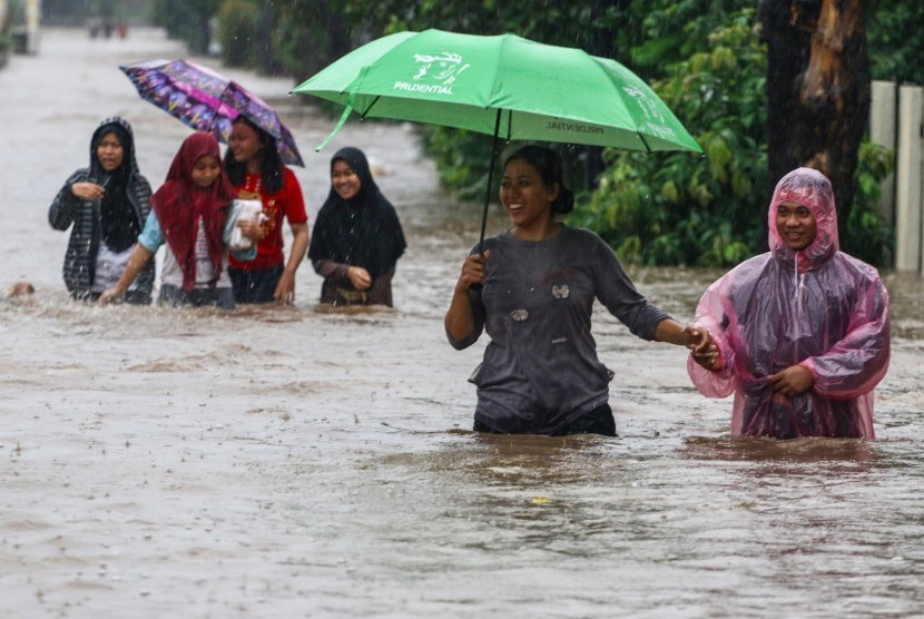 Warga melintasi banjir yang menggenangi Perumahan Pondok Maharta, Pondok Kacang, Tangerang Selatan, Banten, Kamis (1/1/2020). 