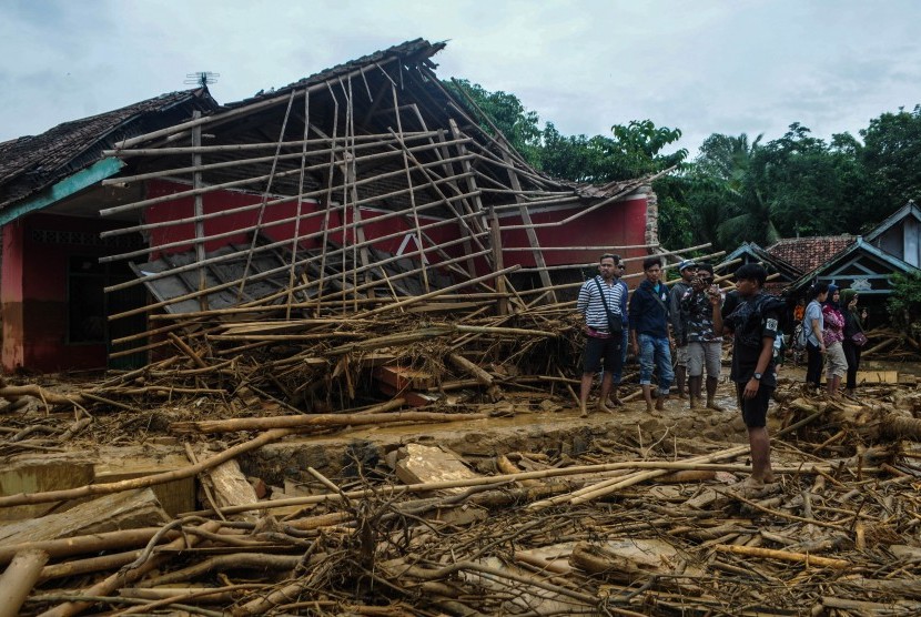 Sejumlah warga melihat kondisi rumah yang rusak akibat diterjang banjir bandang di Desa Sajira, Lebak, Banten, Rabu (1/1/2020).