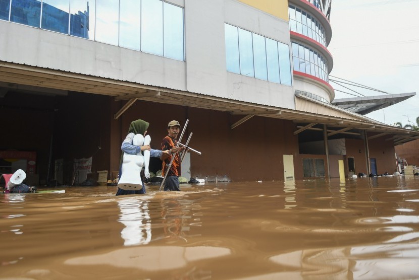 Pedagang mengevakuasi barang dagangannya yang terendam banjir di Mal Cipinang Indah, Jakarta Timur, Rabu (1/1/2020). 