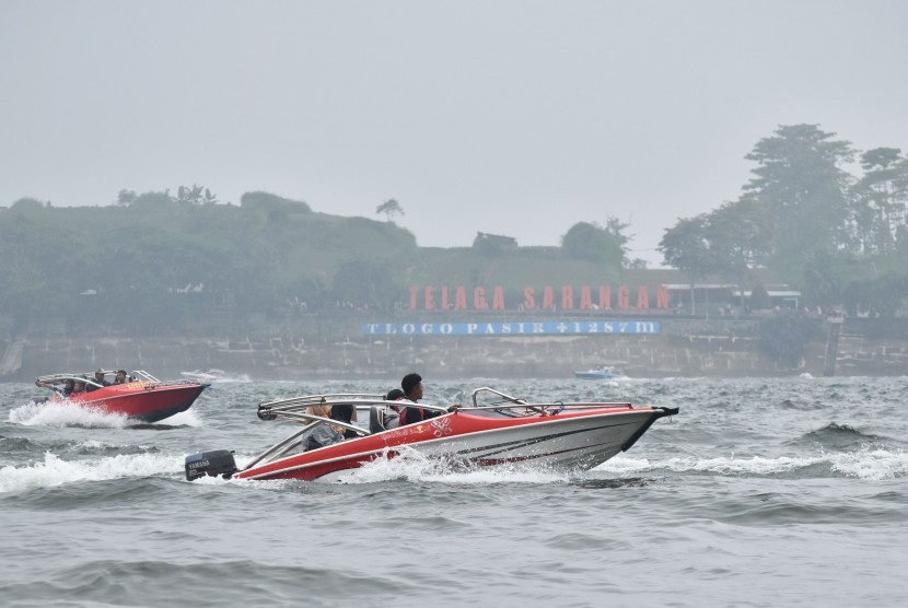 Pengunjung menaiki speedboat mengelilingi Telaga Sarangan, Magetan, Jawa Timur, Rabu (1/1/2020).