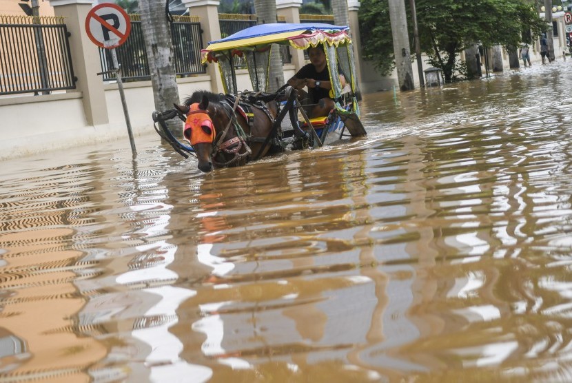 Delman melintasi banjir di kawasan Cipinang Melayu, Jakarta, Rabu (1/1/2020)