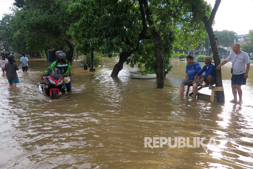 Warga mendorong motornya melintasi genangan banjir di kawasan Pasar Baru, Jakarta Pusat, Kamis (2/1/2020).