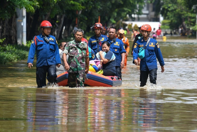 Anggota TNI dan Dinas Pemadam Kebakaran dan Penanggulangan Bencana (Damkar dan PB) DKI Jakarta menarik perahu karet yang dinaiki warga saat melintasi genangan banjir di kawasan Bungur Besar Raya, Jakarta, Kamis (2/1/2020). 