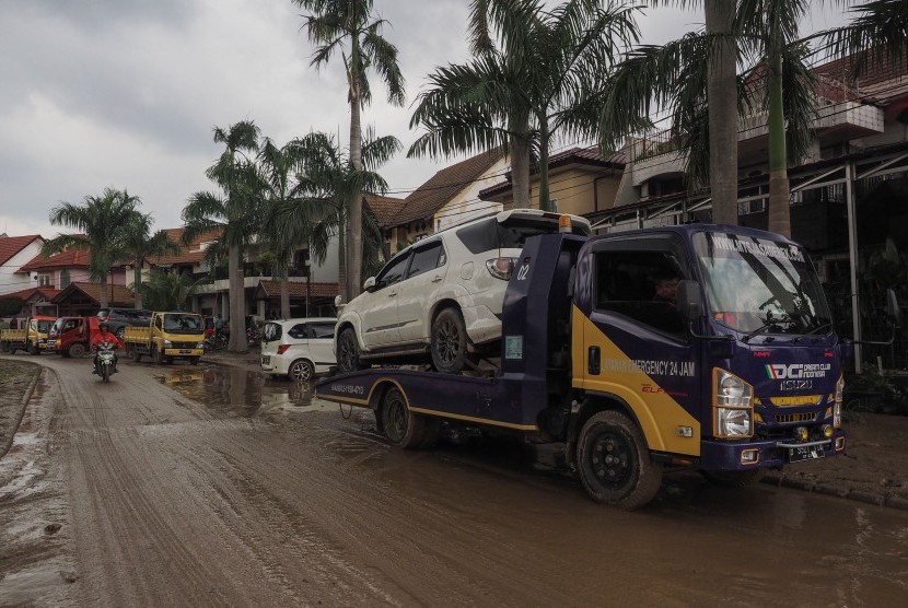 Warga memanfaatkan jasa derek gendong (towing) untuk membawa mobil ke tempat servis dari Perumahan Kemang Pratama di Bekasi, Jawa Barat, Kamis (2/1/2020). 