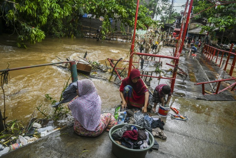 Warga membersihkan perabotan rumah dari endapan lumpur pascabanjir di Kawasan Cipinang Melayu, Jakarta, Kamis (2/1/2020).