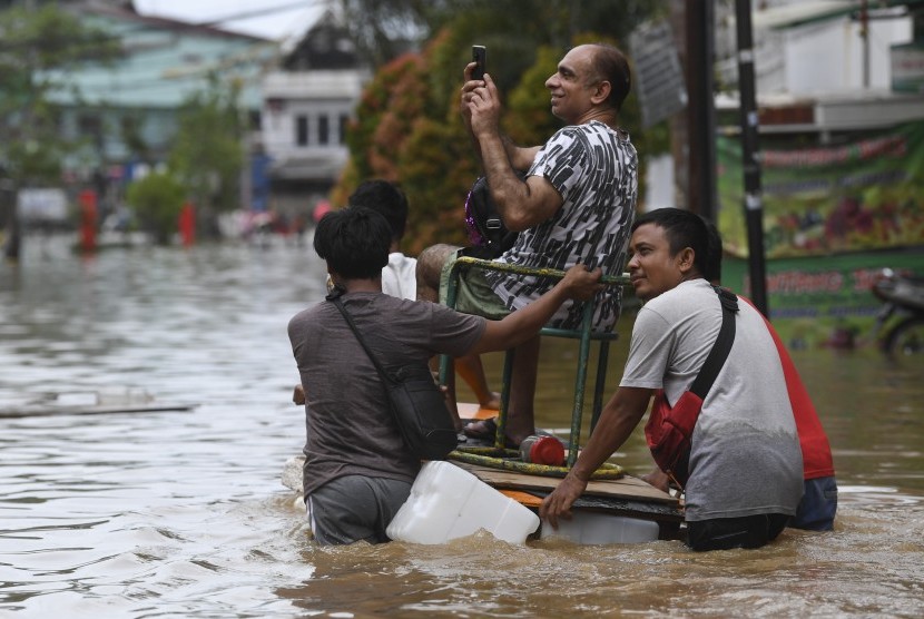 Warga mengevakuasi korban banjir di Pasar Baru, Sawah Besar, Jakarta, Kamis (2/1/2020).