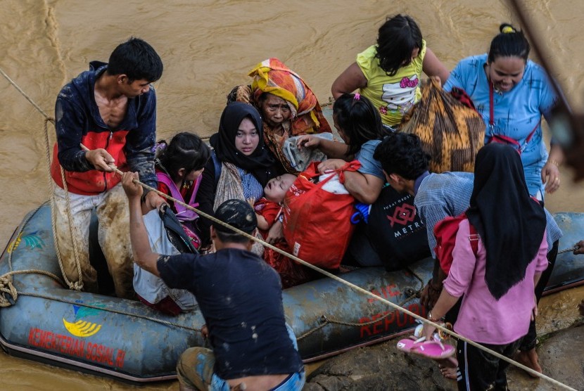 Sejumlah relawan membantu warga menyeberangi Sungai Ciberang untuk dievakuasi ke tempat aman di Kampung Susukan, Lebak, Banten, Kamis (2/1/2020). 