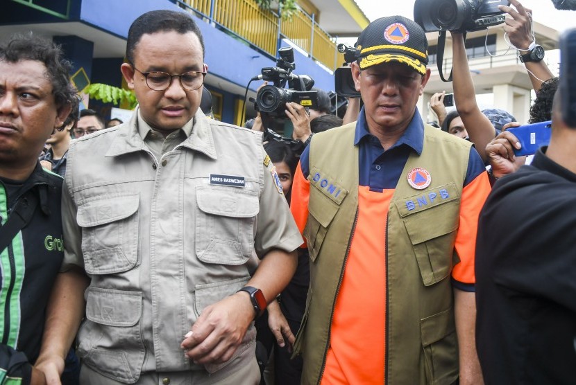 Kepala Badan Nasional Penanggulangan Bencana (BNPB) Letjen TNI Doni Monardo (kanan) berbincang dengan Gubernur DKI Jakarta Anies Baswedan (kiri) saat meninjau pintu air Manggarai, Jakarta, Kamis (2/1/2020). 