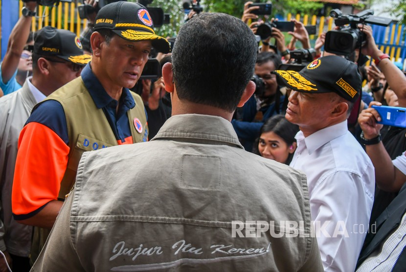 Menteri Koordinator Pembangunan Manusia dan Kebudayaan Muhadjir Effendy (kanan) berbincang dengan Kepala Badan Nasional Penanggulangan Bencana (BNPB) Letjen TNI Doni Monardo (kiri) dan Gubernur DKI Jakarta Anies Baswedan (tengah) saat meninjau pintu air Manggarai, Jakarta, Kamis (2/1/2020).