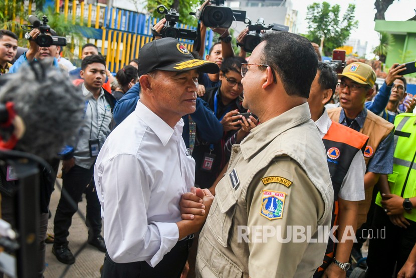 Menteri Koordinator Pembangunan Manusia dan Kebudayaan Muhadjir Effendy (kiri) menjabat tangan dengan Gubernur DKI Jakarta Anies Baswedan (kanan) saat meninjau pintu air Manggarai, Jakarta, Kamis (2/1/2020). 