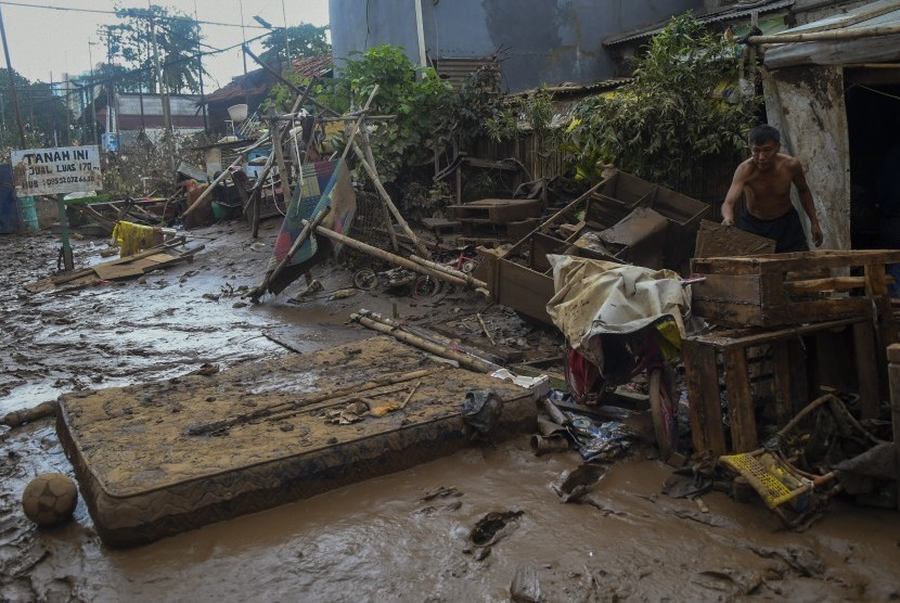  Warga membersihkan endapan lumpur sisa banjir di Rawajati, Jakarta, Kamis (2/1/2020).