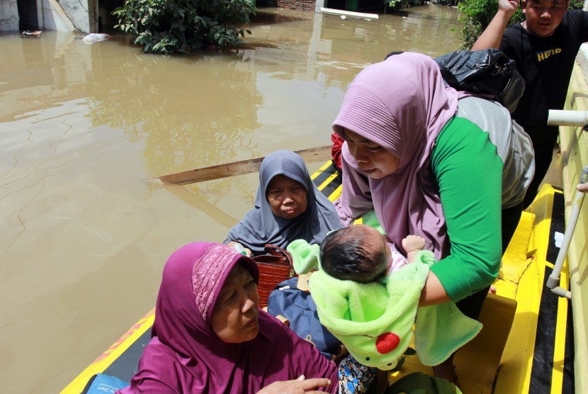 Relawan dan warga melakukan evakuasi bayi yang terjebak banjir. Hanim, seorang bayi berusia empat bulan yang kini berada di pengungsian, sempat dimasukkan kulkas agar selamat dari banjir. Ilustrasi.
