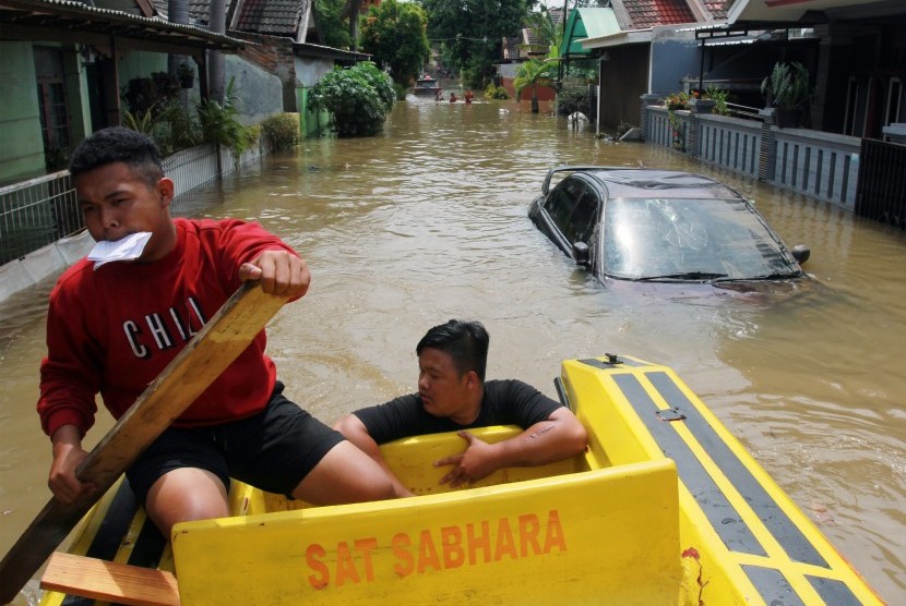 Relawan mendayung perahu untuk melakukan evakuasi warga yang terjebak banjir di dalam rumahnya di Perumahan Pondok Arum, Tangerang, Banten, Kamis (2/1/2019).