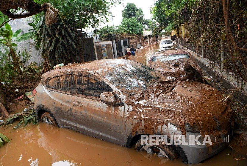 Sebuah mobil yang terseret arus banjir melintang di jalan di Kompleks IKPN Bintaro, Pesanggrahan, Jakarta, Jumat (3/1/2019).
