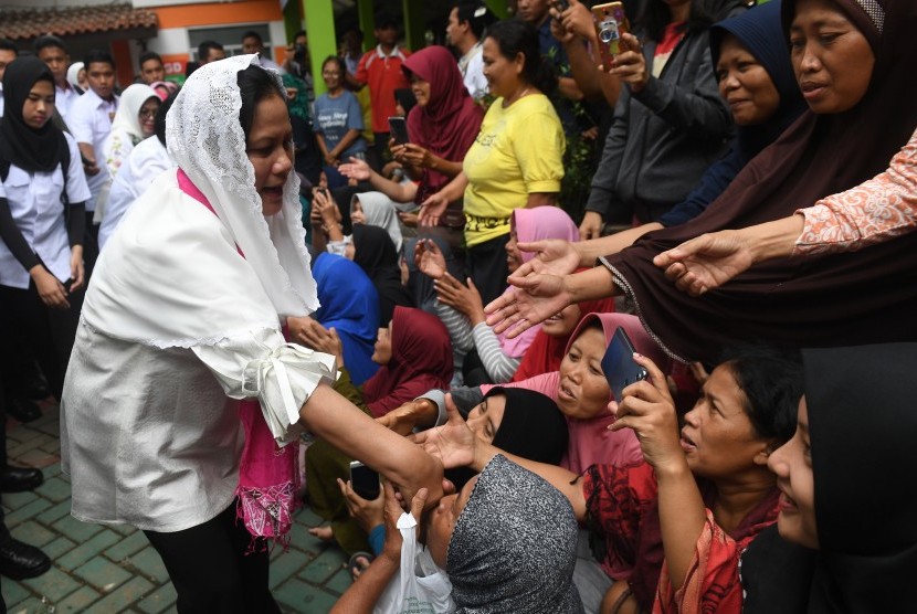 Ibu Negara Iriana Joko Widodo (kiri) berjabat tangan dengan korban banjir saat melakukan kunjungan kerja di Periuk Jaya Permai, Tangerang, Banten, Jumat (3/1/2020).