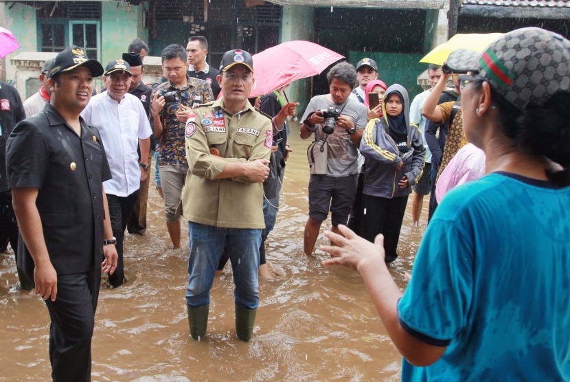 Menteri Sosial Juliari P Batubara (tengah) didampingi Wali Kota Tangerang Arief R Wismansyah (kiri) berbincang dengan korban banjir di Ciledug Indah Tangerang, Banten, Jumat (3/1/2019).