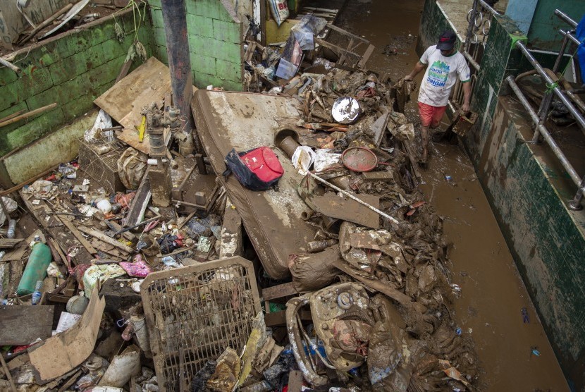 Warga membersihkan sampah pascabanjir yang melanda kawasan Kampung Pulo, Jakarta.