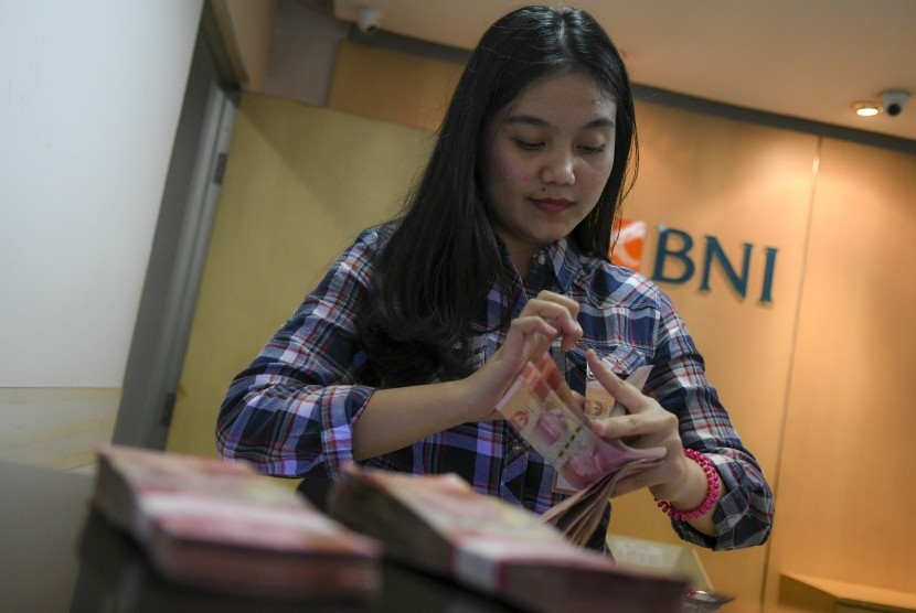 BNI sedang mengkaji untuk membuka cabang di wilayah Indocina seperti Kamboja dan Vietnam. Foto teller menghitung uang rupiah di Bank BNI, (ilustrasi).