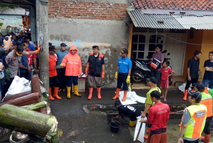 Anies Sebut Korban Banjir tidak Lagi 24 Jam di Pengungsian. Gubernur DKI Jakarta Anies Baswedan saat gotong-royong membersihkan sampah sisa banjir di Lapang Pilar, Jalan Jembatan Lama, Kelurahan Makasar, Jakarta Timur.