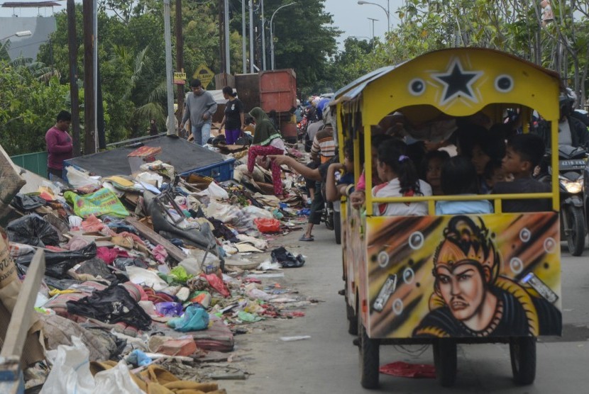 Pemerintah Kota Bekasi, Jawa Barat menerima bantuan sebesar Rp 3 miliar dari Pemerintah Provinsi Jawa Barat dan Badan Nasional Penanggulangan Bencana (BNPB). Foto:Pengguna jalan melaju di samping tumpukan sampah pascabanjir di Duren jaya, Bekasi, Jawa Barat, Ahad (5/1/2020).