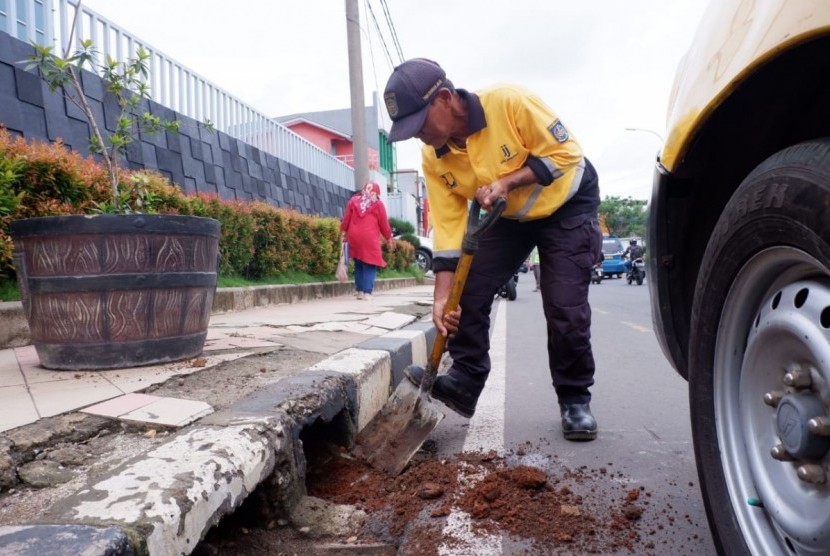 Cegah kembali terjadi banjir, Dinas Pekerjaan Umum dan Penataan Ruang (PUPR) Kota Depok melakukan pembersihan saluran air di sepanjang Jalan Margonda Raya, Kota Depok, Senin (6/1).
