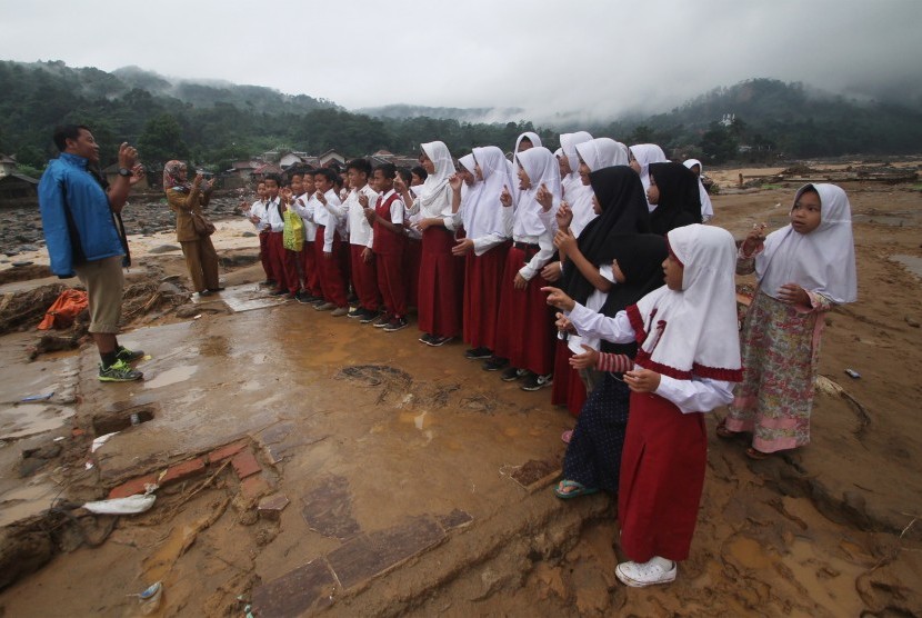 Sejumlah siswa SD Negeri 02 Banjar Irigasi Lebak belajar sambil bermain di atas sisa puing sekolahnya yang hancur di Desa Banjar Irigasi, Kecamatan Lebak Gedong, Kabupaten Lebak, Banten, Senin (6/1/2020).