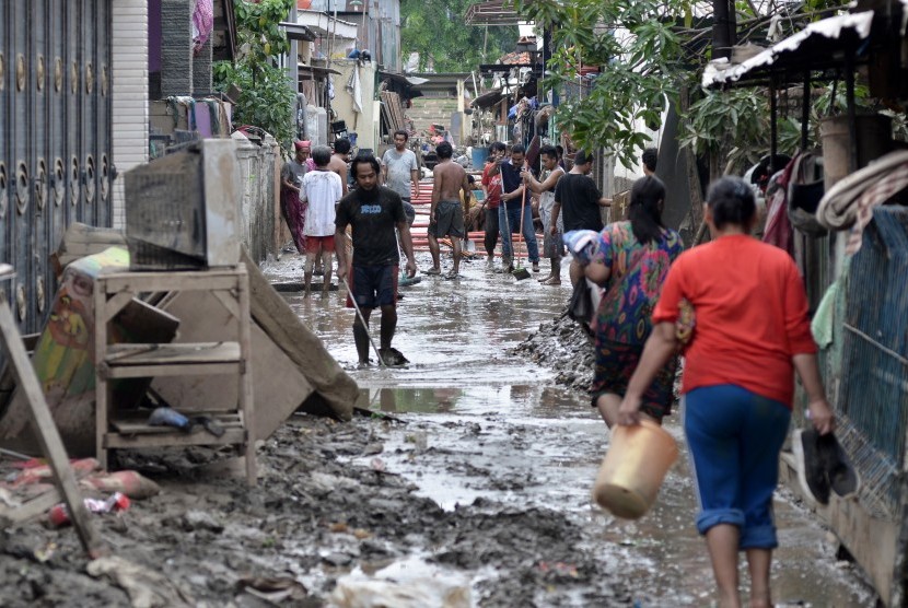 Sejumlah warga membersihkan lumpur pasca banjir yang menggenangi wilayah Jalan Mawar V RT. 008 RW 03, Kelurahan Margahayu, Bekasi Timur, Jawa Barat, Senin (6/1). Status tanggap daruta di Bekasi diperpanjang sepekan.