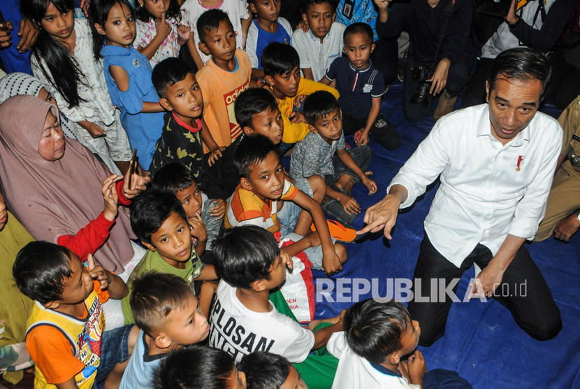 Presiden Joko Widodo (kanan) berdialog korban bencana di Desa Banjar Irigasi, Lebak, Banten, Rabu (7/1/2020).