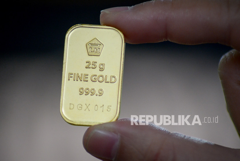 Warga menunjukkan emas batangan 25 gram sebelum dijual di Butik Emas Logam Mulia Antam, Bandung, Jawa Barat, Rabu (8/1/2020). Dikutip dari laman Logam Mulia, harga pecahan satu gram emas Antam berada di level Rp 1.077.000, turun Rp 10 ribu per gram.