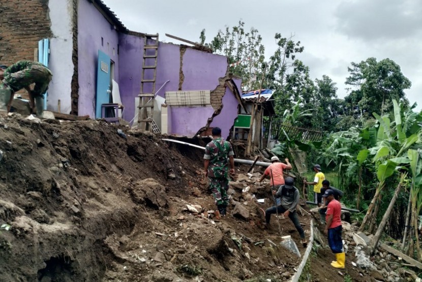 Warga membersihkan sisa material longsoran yang terjadi di Kampung Karangresik, Kelurahan Sukamanah, Kecamatan Cipedes, Kota Tasikmalaya, Rabu (8/1). 